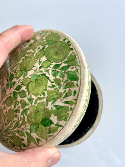 Lifting the lid on a lime green trinket pot handmade in India.