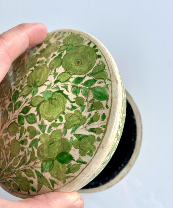 Lifting the lid on a lime green trinket pot handmade in India.