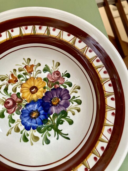 Multi-coloured florals on a vintage brown wall plate from Austria.