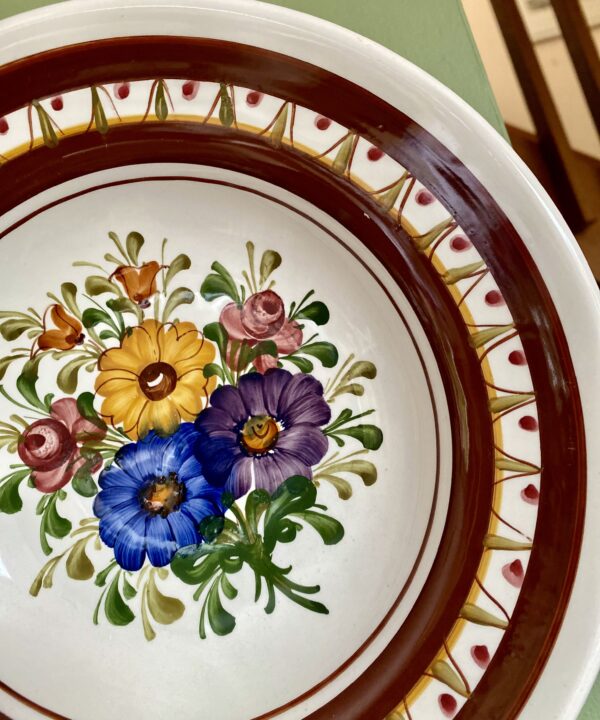 Multi-coloured florals on a vintage brown wall plate from Austria.