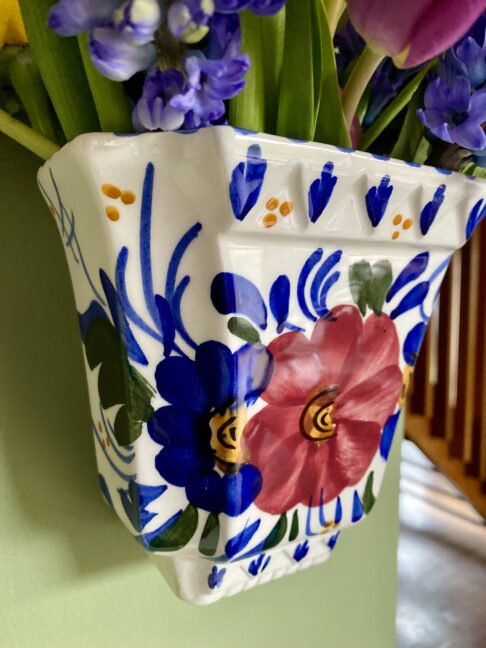 Blue and white decoration on a pretty, vintage wall vase.