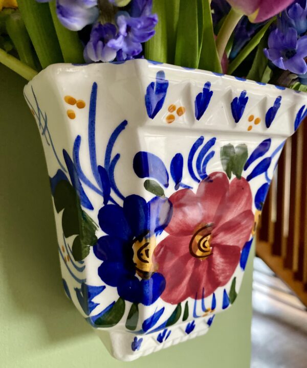 Blue and white decoration on a pretty, vintage wall vase.