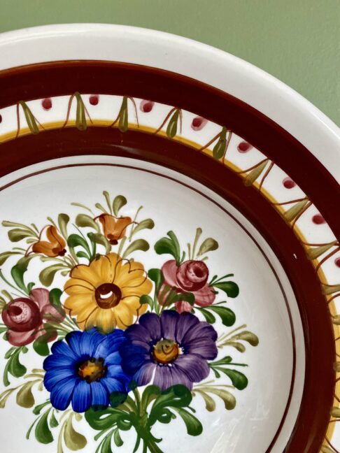 Handmade ceramic wall plate with pretty, multi-coloured floral hand-painting.