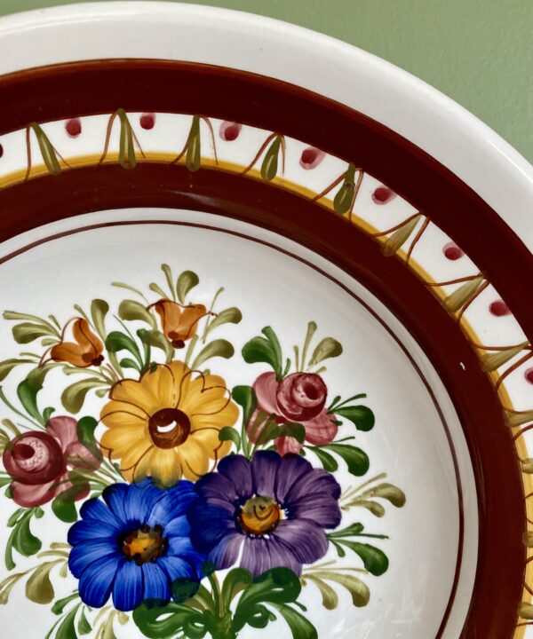 Handmade ceramic wall plate with pretty, multi-coloured floral hand-painting.