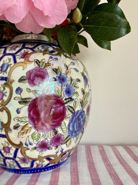 Pretty rose design on a vintage Chinese pot or vase in blue, pink and gold.