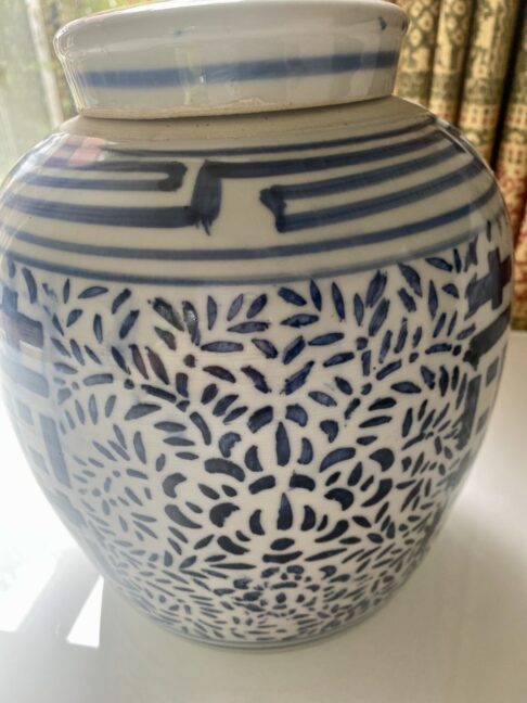 Vintage Chinese pot with lid and blue and white decorative pattern.