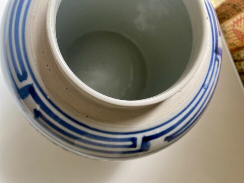 The rim of a vintage Chinese ginger jar with lid.