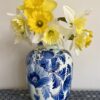 A vintage Delft vase in blue and white floral design. Shown here filled with Spring daffodils.