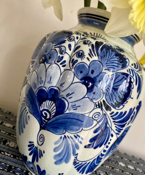 A floral vase with segmented shape and blue colouring.