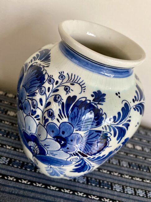 An elegant Delft vase with flowers hand-painted in blue.