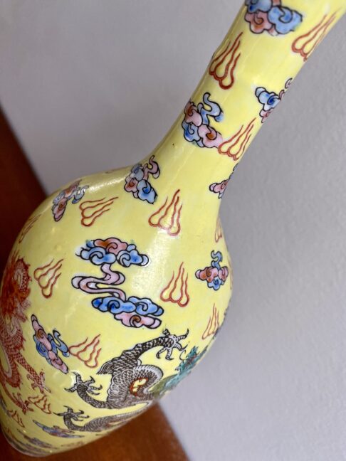 Dragon motifs on a pale yellow bottle vase from China.