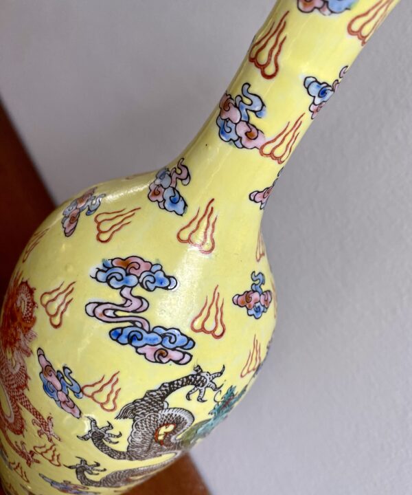 Dragon motifs on a pale yellow bottle vase from China.