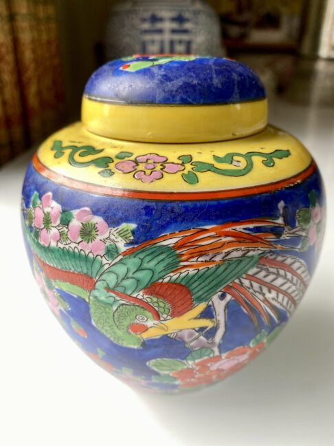 A decorative bird depicted on a vintage Japanese pottery jar.