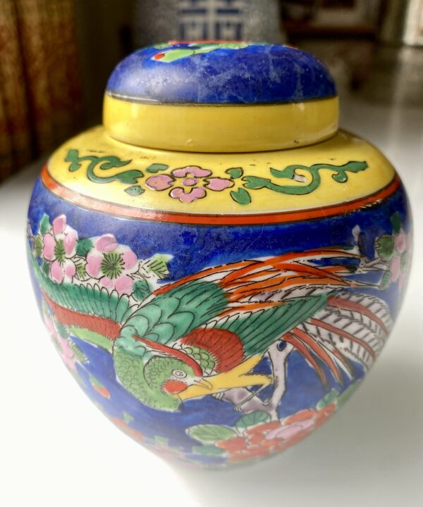A decorative bird depicted on a vintage Japanese pottery jar.