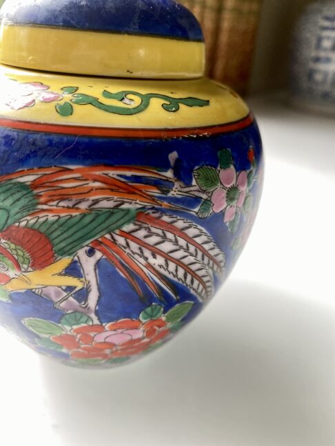 Painted birds and blossom on a brightly-colourful Japanese pottery jar.