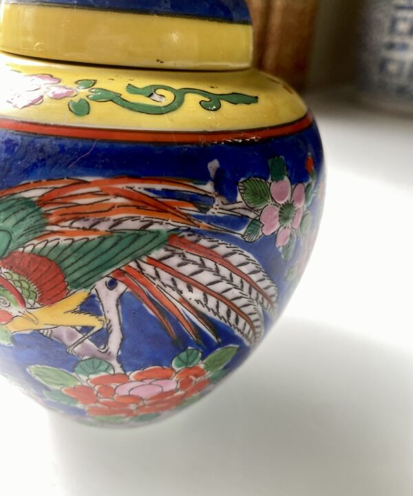 Painted birds and blossom on a brightly-colourful Japanese pottery jar.