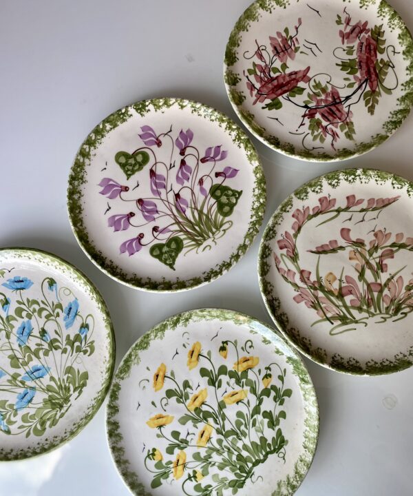 A vintage hand-painted floral wall plate set hailing from Paphos, Cyprus.