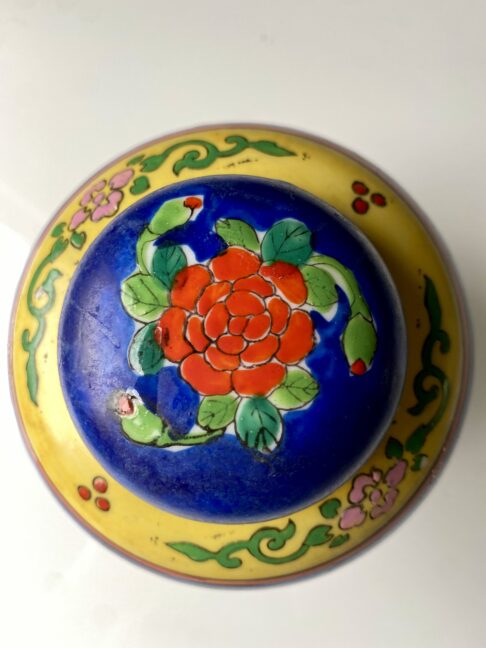 Lid on a vintage Japanese jar depicting a red rose.