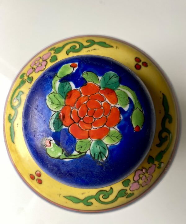 Lid on a vintage Japanese jar depicting a red rose.