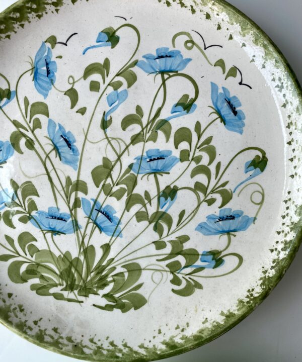 Pretty turquoise blue flowers and green leaves on a vintage, hand-painted wall-plate.