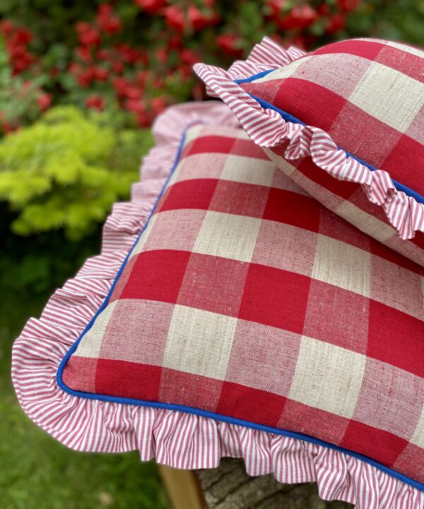 Red and white cushions in a giant check made from vintage French linen and striped cotton with a blue trim.