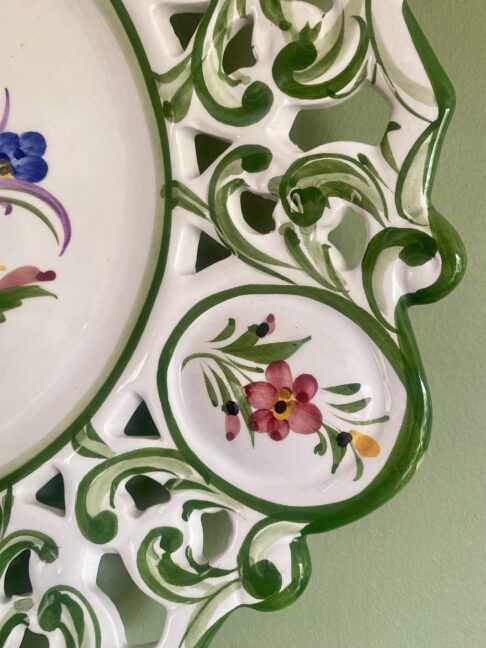 Flower detail on a large, hand-painted decorative wall plate from Portugal.