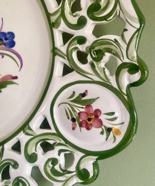 Flower detail on a large, hand-painted decorative wall plate from Portugal.