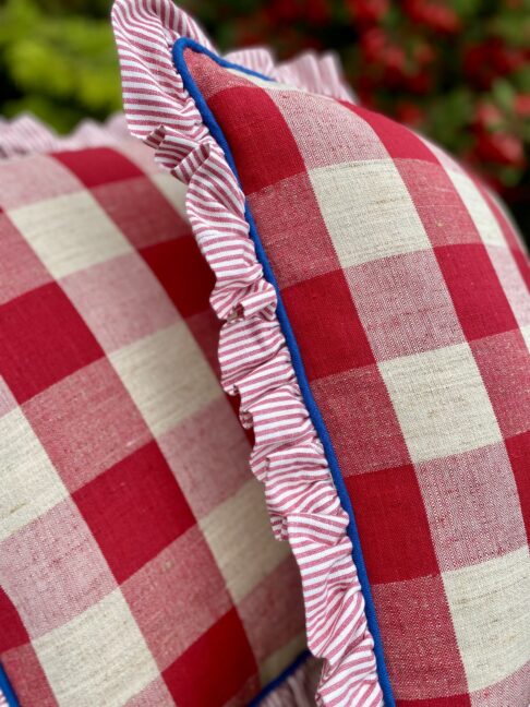 Pretty red and white check cushions in vintage linen with a striped frill and blue piped edges.