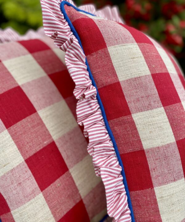 Pretty red and white check cushions in vintage linen with a striped frill and blue piped edges.