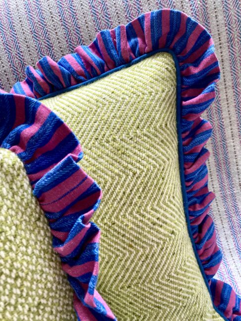 Frilly cushions with pink and blue striped linen trim and Donegal tweed cover.