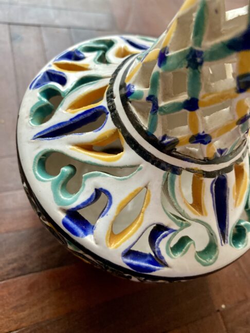 Hand-painted yellow, green and blue detail on a pierced vintage pot.