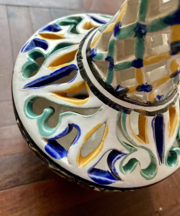 Hand-painted yellow, green and blue detail on a pierced vintage pot.