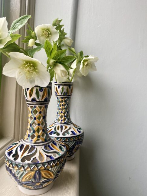 A pair of hand-painted vintage vases with pierced decoration.