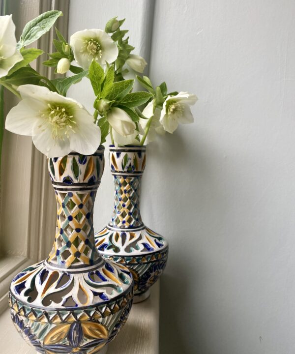 A pair of hand-painted vintage vases with pierced decoration.