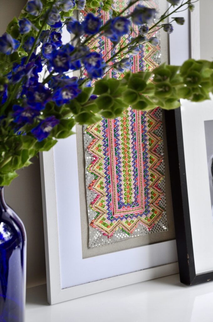 A sparkly sequinned Thai textile panel framed as wall art.