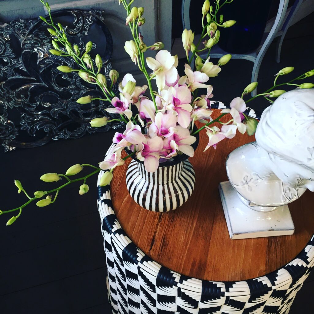 A spray of pink and white orchids in a handmade Thai vase.