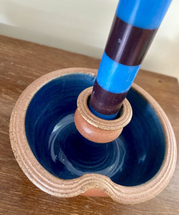 A blue and terracotta-coloured rustic candle holder made by a Scottish artisan potter.