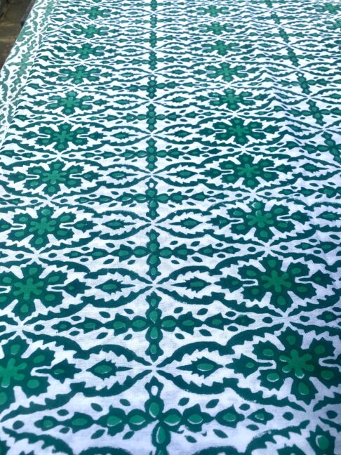 An intricately patterned block print tablecloth in green.