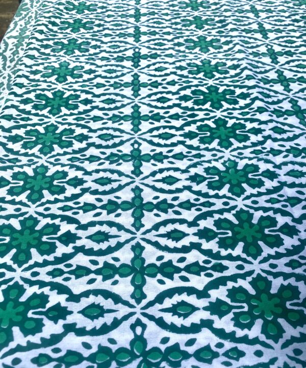 An intricately patterned block print tablecloth in green.